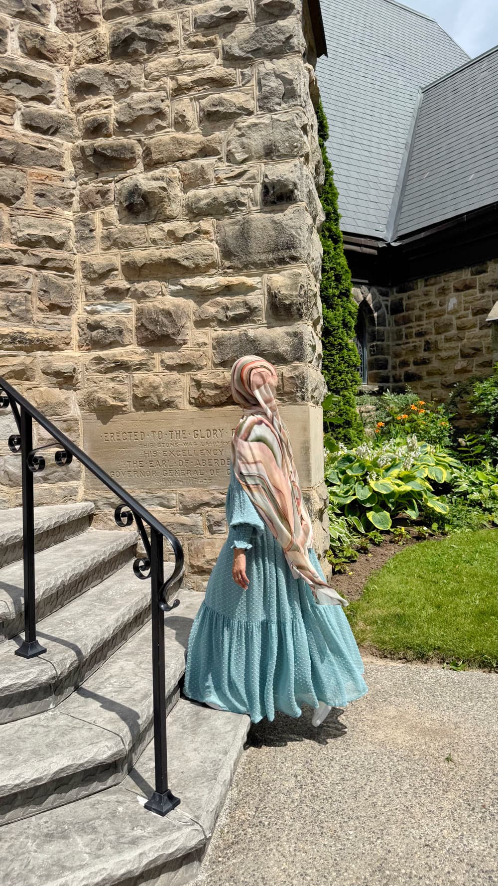 A blue dress beside a historic stone building